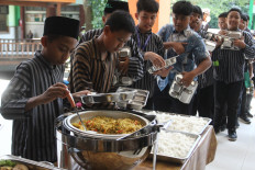 Students queue to serve themselves buffet-style during a pilot implementation of the free meals program on April 2 at Madrasah Ibtidaiyah Islamiyah school 2 in Malang, East Java. The self-service system is intended to foster student independence and reduce food waste, while supporting government efforts to improve nutrition among schoolchildren and enhance health and learning outcomes.