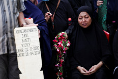 The mother of Arinjani Novita Sari, 25, who was killed in the deadly collision between a commuter line train and a long-distance train on Monday, reacts during her daughter's funeral in Bekasi, West Java, April 29, 2026. 