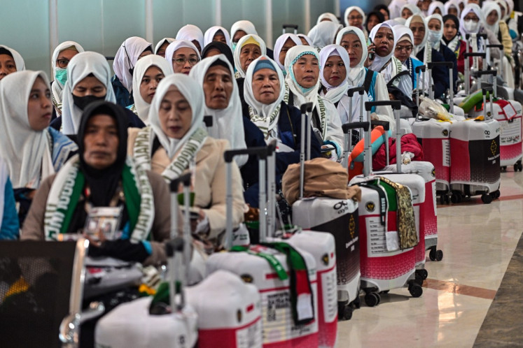 A group of women wait to board their flight on April 22, 2026, at Juanda International Airport in Sidoarjo, which serves East Java capital Surabaya, as they prepare to depart on the annual haj to Mecca, Saudi Arabia.