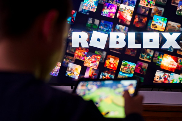 A child plays the Roblox video game on March 11, 2026, on a mobile tablet in Terville, northeastern France.