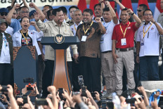 President Prabowo Subianto (second left) stands with leaders of labor groups on Friday during the commemoration of Labor Day at the National Monument (Monas) complex in Jakarta.