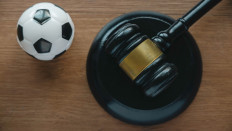An illustration of a gavel and a soccer ball