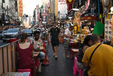 This photo taken on April 29, 2026 shows visitors eating local street food in Chinatown in Bangkok. Across Bangkok, aromas of garlic, chili and grilled meat drift from roadside stalls and carts, but tighter controls on vendors threaten livelihoods and the street food culture that defines the Thai capital.
