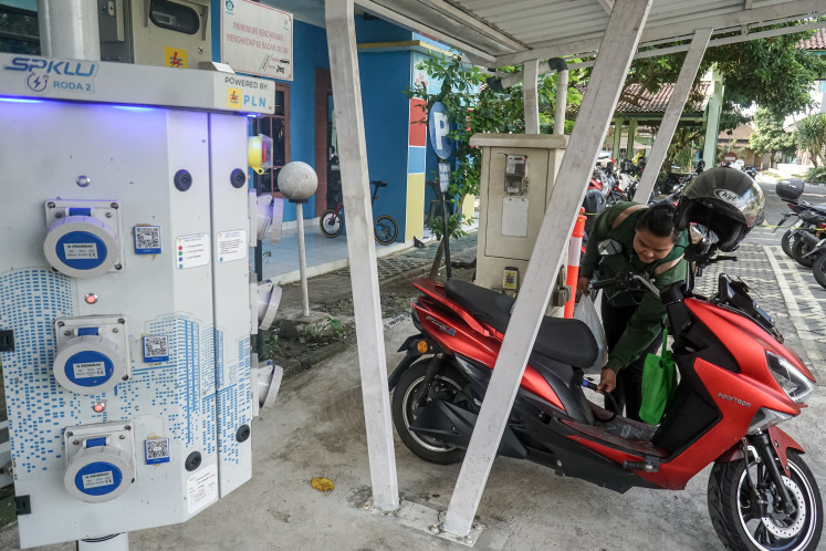 Green energy: An electric vehicle user charges a motorcycle on April 20 at a public electric vehicle charging station operated by PLN UP3 in Surakarta, Central Java.