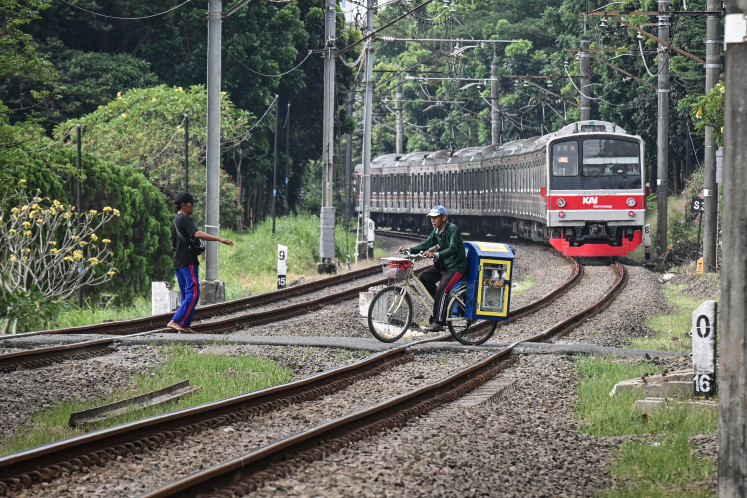 Deadly shortcut: People cross railway tracks on May 3 in the Tanah Kusir area of Kebayoran Lama, South Jakarta. State-owned railway company Kereta Api Indonesia (KAI) said 130 of the 423 railway crossings in its Daop 1 Jakarta operational area remain unguarded, prompting plans for joint enforcement with local authorities to improve transportation and public safety.