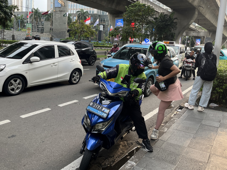 Fast, cheap, ubiquitous: An 'ojol' (online motorcycle transportation) driver drops off a passenger on May 3, 2026, in front of a shopping mall on Jl. Prof. Dr. Satrio in South Jakarta.