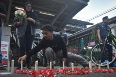 People take part in a flower-strewing ceremony on April 30 to pray for the victims of a train collision, at Bekasi Timur Station in Bekasi, West Java.