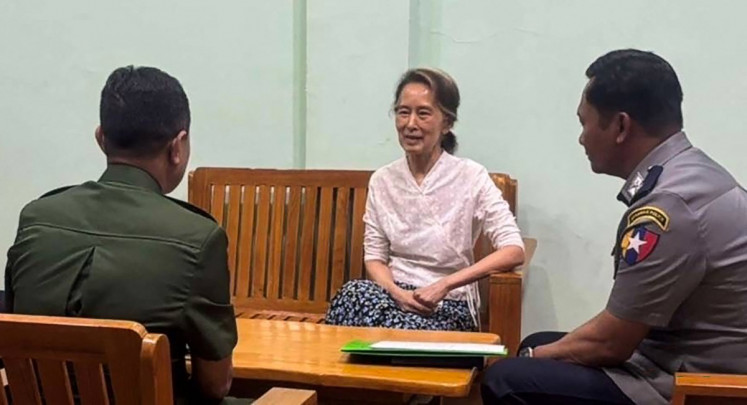 Aung San Suu Kyi (center) talks to Myanmar security forces personnel from the military (left) and the police in an undisclosed location, in this undated handout photo from the Myanmar Military Information Team released on April 30, 2026.