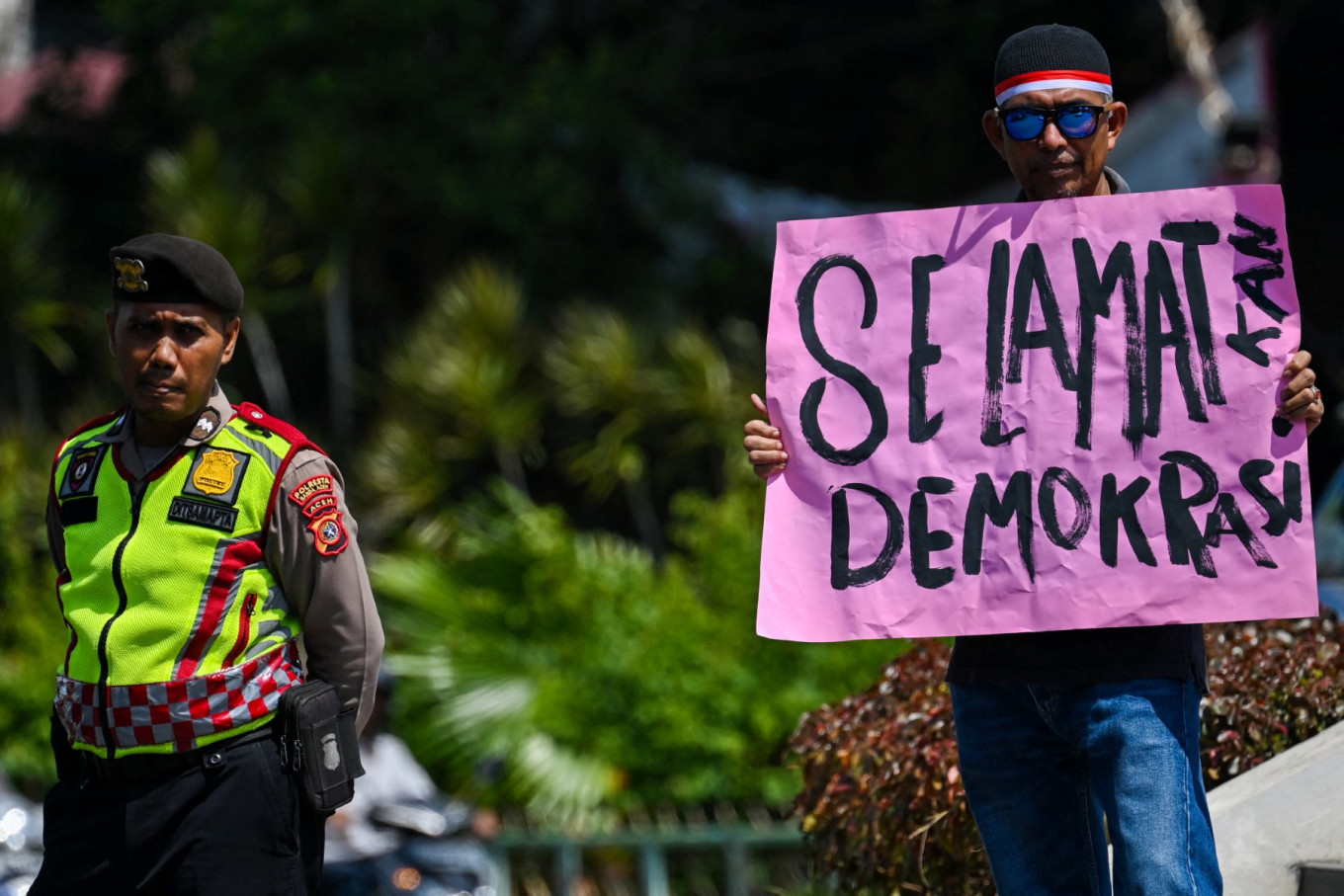 A demonstrator holds a banner reading &ldquo;Save democracy&rdquo; on March 20, 2024, during a protest in Aceh&rsquo;s provincial capital Banda Aceh alleging fraud in the 2024 general election.