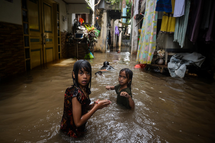 Children play on May 5, 2026, in floodwaters in Bojong Kavling, Rawa Buaya, West Jakarta. The Jakarta Disaster Mitigation Agency reported that as of 2 p.m., 18 neighborhood units and one road remained inundated, with water levels ranging from 15 to 95 centimeters following heavy rainfall that caused rivers to overflow.