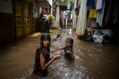 Children play on May 5, 2026, in floodwaters in Bojong Kavling, Rawa Buaya, West Jakarta. The Jakarta Disaster Mitigation Agency reported that as of 2 p.m., 18 neighborhood units and one road remained inundated, with water levels ranging from 15 to 95 centimeters following heavy rainfall that caused rivers to overflow.