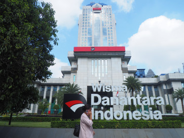 A woman walks on May 6, 2026, past the Wisma Danantara Indonesia building on Jl. Jend. Gatot Subroto in South Jakarta.