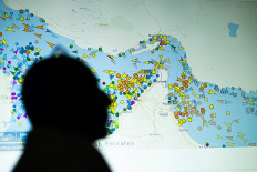 A photo illustration taken on May 4, 2026 in Nicosia, shows a person in front of a large screen displaying vessel movements in the Strait of Hormuz on a ship-tracking website.