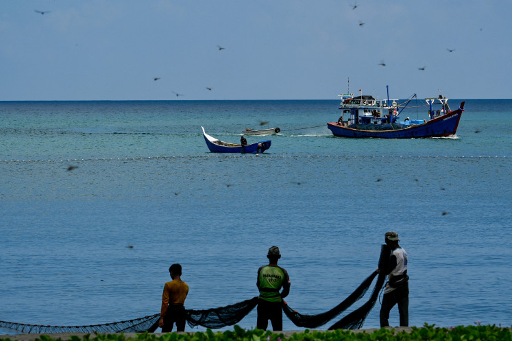 Chasing the catch: Fishermen pull up their nets on March 12 on a beach in Banda Aceh, Aceh.