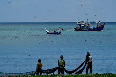 Chasing the catch: Fishermen pull up their nets on March 12 on a beach in Banda Aceh, Aceh.
