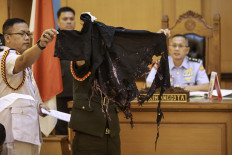 A military prosecutor (left) presents during a follow-up hearing at Military Court II-08 Jakarta on May 6, 2026, a shirt worn by Kontras activist Andrie Yunus when he suffered an acid attack on March 12. The hearing featured testimony from eight witnesses, five members of the Indonesian Military and three civilians, presented by the military prosecutor.