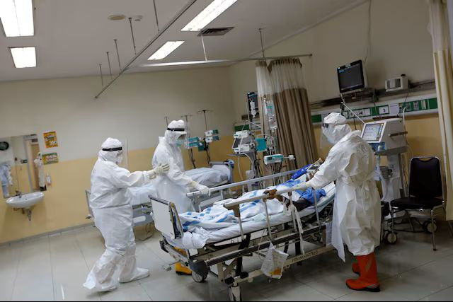 Health workers in protective suits prepare a patient on May 13, 2020, for transferring from the COVID-19 intensive care unit to the surgical unit at Persahabatan Central General Hospital in Pulo Gadung, East Jakarta.