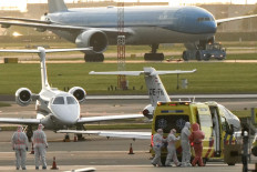 A person in a hazmat suit (2nd right) is escorted to a ambulance from a medical aircraft allegedly carrying some of the passengers from the cruise ship MV Hondius believed to be infected with hantavirus, at Schiphol airport near Amsterdam on May 6, 2026. 