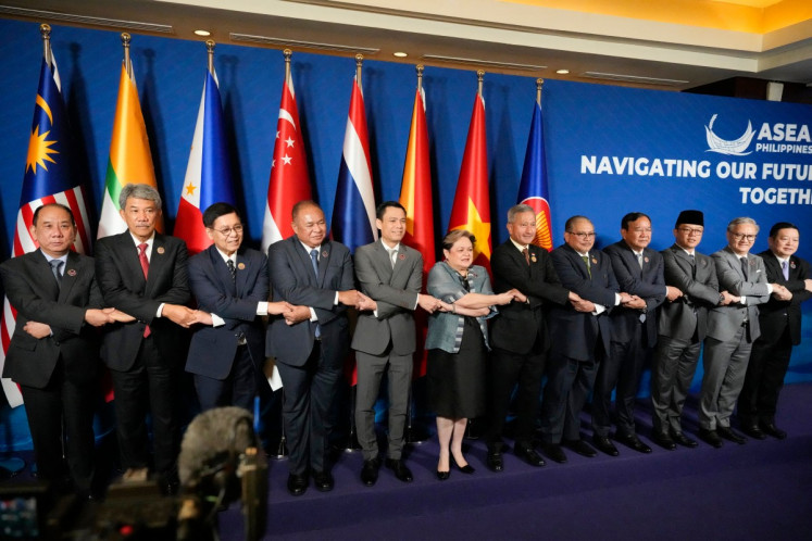 (L-R) Myanmar's Permanent Secretary of the Ministry of Foreign Affairs U Hau Khan Sum, Malaysia's Foreign Minister Mohamad Hasan, Thailand's Foreign Minister Sihasak Phuangketkeow, Timor Leste's Foreign Minister Bendito dos Santos Freitas, Vietnam's Deputy Minister of Foreign Affairs Dang Hoang Giang, Philippine's Foreign Secretary Theresa Lazaro, Singapore's Foreign Minister Vivian Balakrishnan, Brunei's Second Foreign Minister Erywan Pehin Yusof, Cambodia's Foreign Minister Prak Sokhonn, Indonesia's Foreign Minister Sugiono, Lao's Foreign Minister Thongsavanh Phomvihane, and ASEAN Secretary General Kao Kim Hourn hold hands during a group photo session at the ASEAN Foreign Ministers Meeting at the Mactan Expo in Cebu on May 7, 2026.