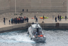 Activists from the Global Sumud aid flotilla stand at the port of Atherinolakkos on May 1 on the island of Crete after disembarking from a Greek Coast Guard vessel, following their interception by the Israeli Navy in international waters.