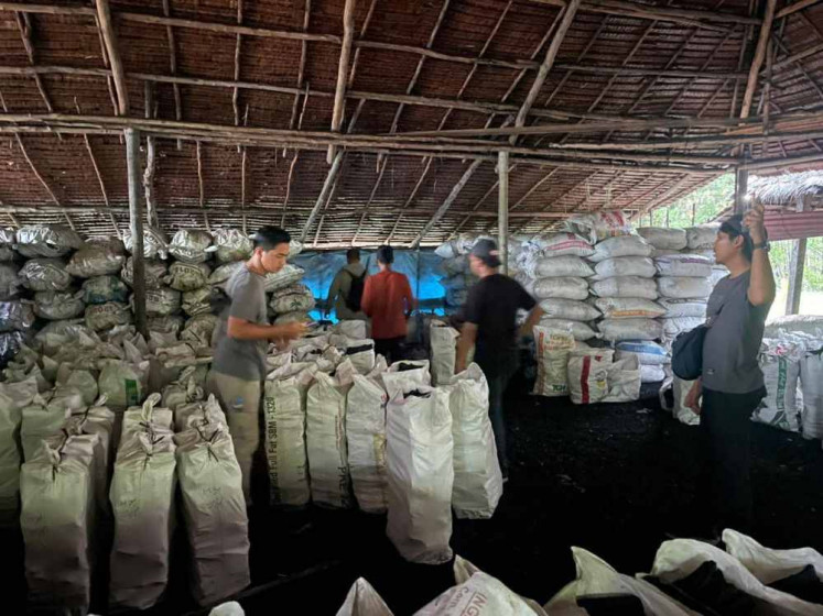 Plainclothes officers from the special criminal investigation unit inspect around 3,000 sacks of mangrove charcoal during a raid on an illicit charcoal factory in eastern Meranti Islands regency, in this undated handout photo provided by the Riau Police on May 6, 2026.
