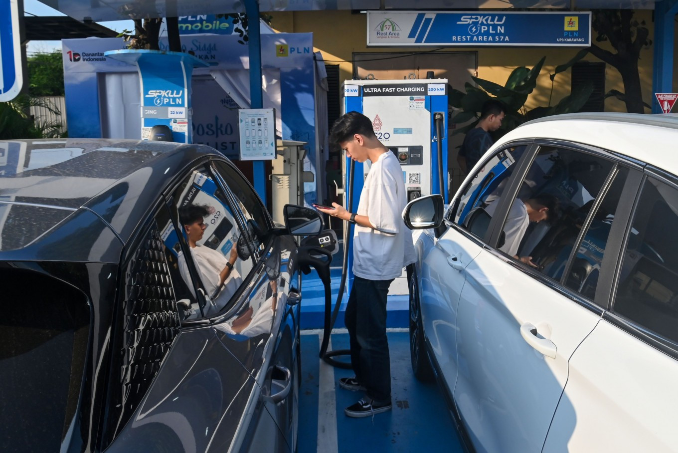 Powering up: A traveler charges an electric vehicle on March 15, 2026, at a public EV charging station operated by energy giant PT PLN at a rest area on the Jakarta-Cikampek toll road in Karawang Regency, West Java. The transition to transportation electrification requires political will, as well as subsidies and a clear long-term strategy