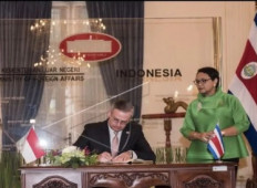 Costa Rican Foreign Minister Manuel Antonio Gonzales Sanz signs the guest book as his counterpart Retno Marsudi looks on at the Indonesian Foreign Ministry in Jakarta on Sept. 3, 2017.