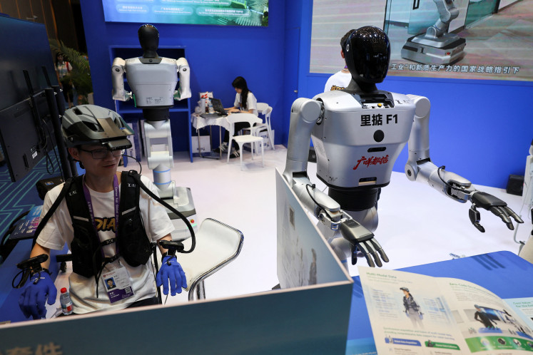 An employee demonstrates the working of a humanoid robot during the China Import and Export Fair, commonly known as the Canton Fair, in Guangzhou, Guangdong province, China, on April 15, 2026.