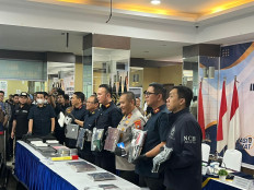 Immigration Director General Hendarsam Marantoko (third left) holds evidence, consisting of passports and electronic devices, together with other Immigration officials, Riau Islands Police chief Insp. Gen. Asep Safrudin (third right) and Indonesian Interpol National Central Bureau (NCB) secretary Brig. Gen. Untung Widiatmoko during a press conference on May 8 in Batam, Riau Islands. Immigration officers raided an international scam network at Baloi View Apartment in Batam on Wednesday, May 8, and arrested 210 foreigners.