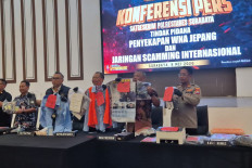 Surabaya Police chief Sr. Comr. (third right) Luthfie Sulistiawan is flanked by Indonesian Interpol National Center Bureau (NCB) Transnational Crimes Department head Sr. Comr. Ricky Purnama (third left), Surabaya Police Crimes Investigation (Reskrim) unit chief Adj. Sr. Comr. Edy Herwiyanto (second) right and other officials hold pieces of evidence during a press conference in Surabaya on May 08, 2026. Surabaya Police have dismantled an international scamming ring, consisting of 44 suspects from China, Indonesia, Japan and Taiwan. 