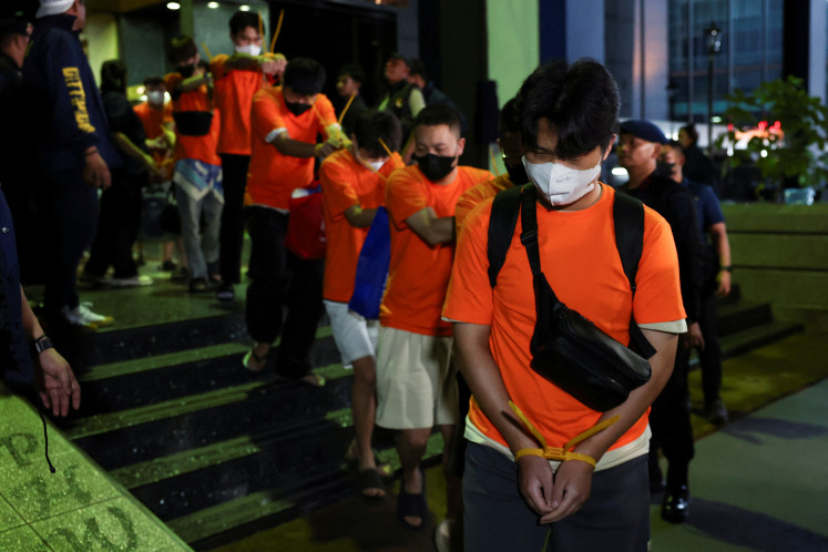 Foreign nationals, who police said were mainly from Vietnam, suspected of running an online gambling operation for two months at an office building, are led to transportation after being arrested on May 10 in Jakarta.. 