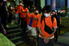 Foreign nationals, who police said were mainly from Vietnam, suspected of running an online gambling operation for two months at an office building, are led to transportation after being arrested on May 10 in Jakarta.. 