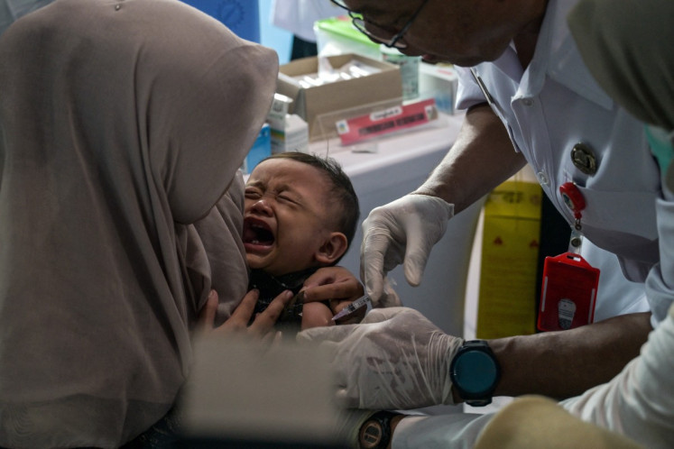 This photo taken on May 6, 2026 shows a child receiving a measles-rubella vaccine as part of the governments health program to combat childhood diseases in Surabaya.