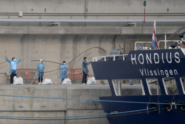 Passengers of the hantavirus-stricken cruise ship MV Hondius gesture after disembarking in the port of Granadilla de Abona on the island of Tenerife in Spain's Canary Islands on May 11, 2026.