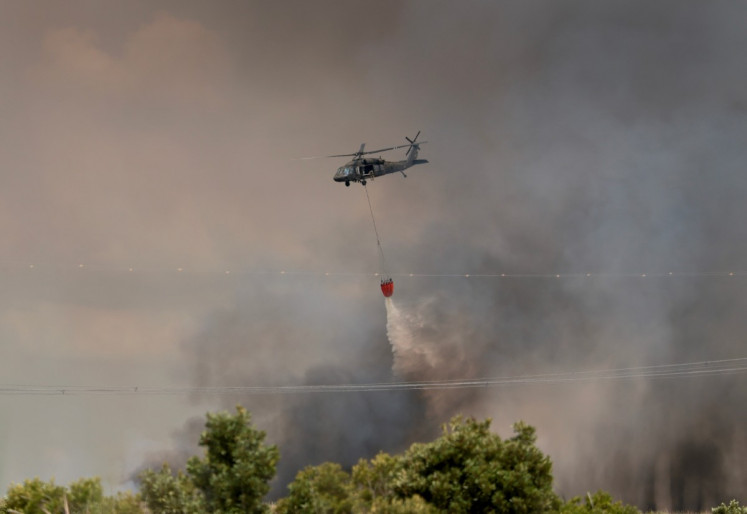 A Florida National Guard helicopter dumps water on the Max Road Miramar fire on May 11, 2026 in Pembroke Pines, Florida, United States.