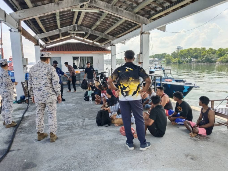 Survivors who were rescued sit after a boat believed to be carrying undocumented Indonesian migrants sank off the coast of Pangkor Island, Malaysia in this undated handout released May 12, 2026. 