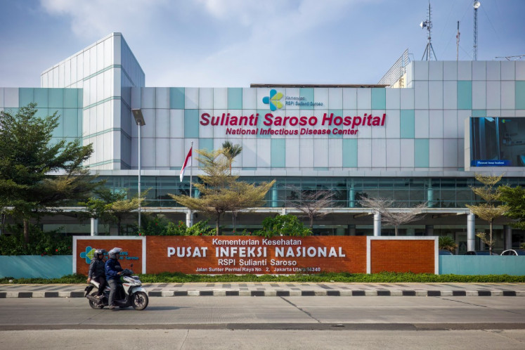 Motorcyclists ride past the Sulianti Saroso Infectious Diseases Hospital in Jakarta on May 12, 2026, where a male British national was quarantined due to suspected hantavirus exposure, although he was eventually declared uninfected.
