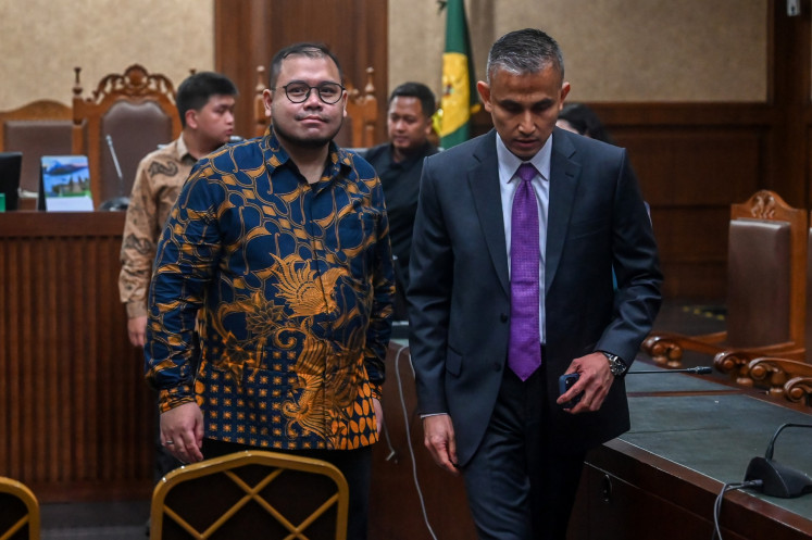 Technology consultant and graft defendant Ibrahim Arief (left) walks with his lawyer after the verdict hearing against him at the Jakarta Corruption Court in Jakarta on May 12, 2026. The judges sentenced him to four years in prison after finding him guilty of jointly committing corruption with other defendants in the procurement of Google Chromebook laptops for schoolchildren.