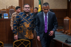Technology consultant and graft defendant Ibrahim Arief (left) walks with his lawyer after the verdict hearing against him at the Jakarta Corruption Court in Jakarta on May 12, 2026. The judges sentenced him to four years in prison after finding him guilty of jointly committing corruption with other defendants in the procurement of Google Chromebook laptops for schoolchildren.