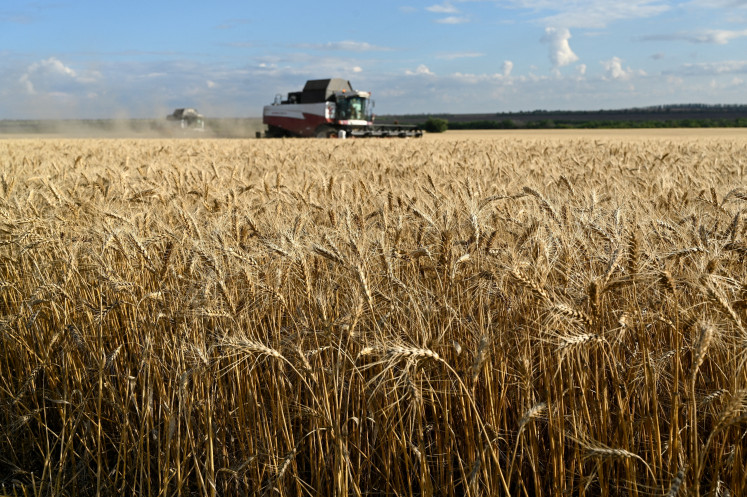 Сombines harvest wheat in a field in the Kasharsky district of the Rostov region, Russia, on July 24, 2025.