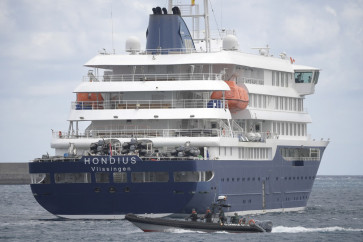 A Spain's Guardia Civil boat sails next to Dutch flagged hantavirus-stricken cruise ship MV Hondius in the port of Granadilla de Abona on the island of Tenerife in Spain's Canary Islands on May 11, 2026. A complex repatriation operation from the Canary Islands on May 10 flew out 94 passengers and crew of 19 different nationalities from the Dutch-flagged MV Hondius, which had been at the center of an international alert after three passengers died.