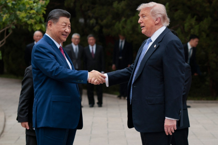 US President Donald Trump (right) shakes hands with China's President Xi Jinping as he leaves after a visit to Zhongnanhai Garden in Beijing on May 15, 2026.