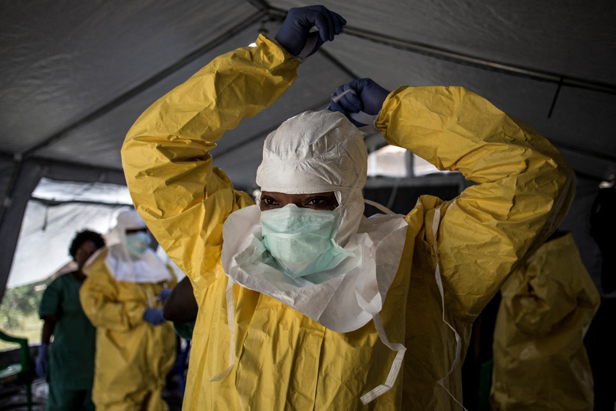 In this file photo, a medical worker puts on her personal protective equipment (PPE) ahead of entering an Ebola treatment center on August 12, 2018, in Beni, the Democratic Republic of the Congo.