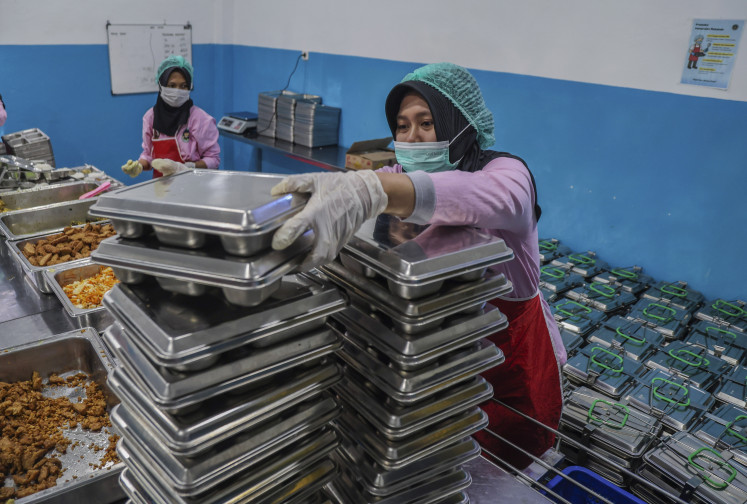 Stacked odds: A worker arranges covered trays filled with freshly cooked food on May 6, 2026, at a nutrition fulfillment service unit (SPPG) based in the Ternate Police headquarters in North Maluku.