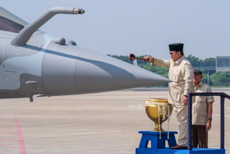President Prabowo Subianto splashes blessed water onto a Rafale jet fighter during a ceremony to hand over six new Rafale jet fighters, four Dassault Falcon 8X aircrafts and one Airbus A400M Atlas aircraft to the Indonesian Air Force at Halim Perdanakusuma Air Force Base in Jakarta on May 18, 2026. 
