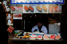 A vendor works at a shop selling sushi rolls at Tsukiji Outer Market in Tokyo on Feb. 16, 2026.