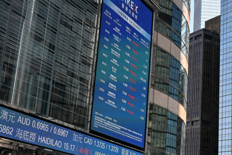 An electronic signboard shows the closing prices of stocks at the end of the day's trade outside the Hong Kong Exchanges and Clearing (HKEX) building in Hong Kong on March 23, 2026.