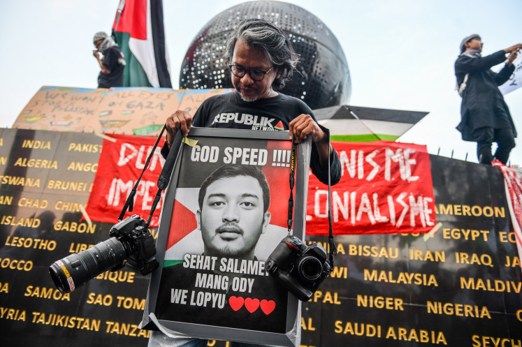 Senior photojournalist Yogi Ardhi holds a photograph of Republika photojournalist Thoudy Badai, one of the journalists allegedly abducted by Israel, during a solidarity rally for Indonesian citizens and journalists on Asia Afrika Street in Bandung, West Java, Tuesday (May 19, 2026). During the rally, members of Solidaritas Seni Untuk Palestina called on the government to secure the release of Indonesian nationals and journalists who were allegedly abducted by Israel while carrying out the Global Sumud Flotilla mission bound for Gaza in Cypriot waters on May 18, 2026. 