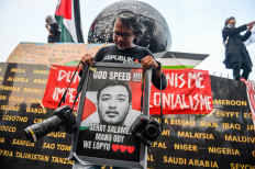 Senior photojournalist Yogi Ardhi holds a photograph of Republika photojournalist Thoudy Badai, one of the journalists allegedly abducted by Israel, during a solidarity rally for Indonesian citizens and journalists on Asia Afrika Street in Bandung, West Java, Tuesday (May 19, 2026). During the rally, members of Solidaritas Seni Untuk Palestina called on the government to secure the release of Indonesian nationals and journalists who were allegedly abducted by Israel while carrying out the Global Sumud Flotilla mission bound for Gaza in Cypriot waters on May 18, 2026. 