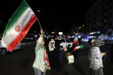 Women hold Iran's national flags and photos of country's supreme leader Ayatollah Mojtaba Khamenei and his predecessor and late father Ayatollah Ali Khamenei during an anti-US and Israel protest at the Hafte Tir Square in Tehran on May 17, 2026.